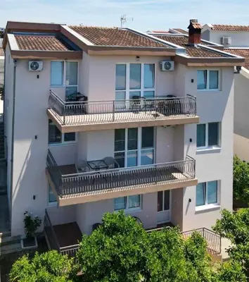 an apartment building with balconies and trees at Kasneci Apartments in Ulcinj