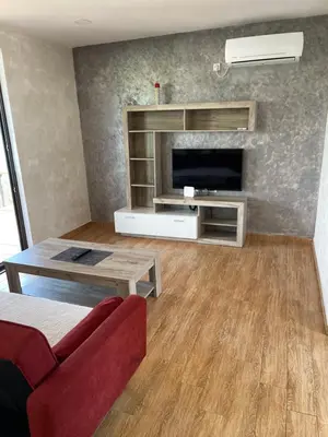a living room with a red couch and a television at Lake River House Ada Bojana in Ulcinj