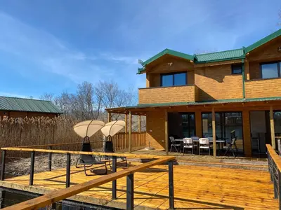 a house with a wooden deck with umbrellas on it at Lake River House Ada Bojana in Ulcinj