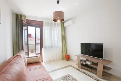 a living room with a couch and a television at Anatolia - Family Sea View one-bedroom apartment in Budva