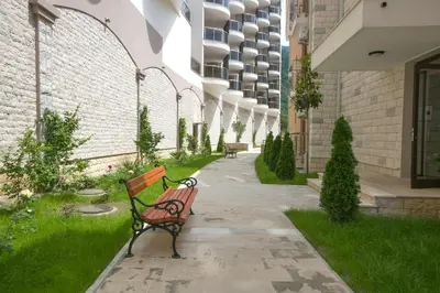 a bench sitting on a sidewalk next to a building at Anatolia - Family Sea View one-bedroom apartment in Budva