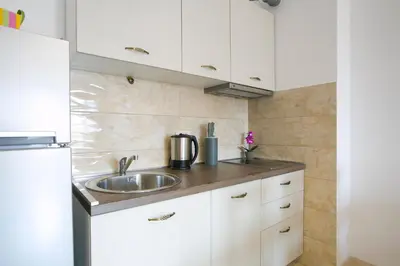 a kitchen with white cabinets and a sink at Anatolia - Family Sea View one-bedroom apartment in Budva