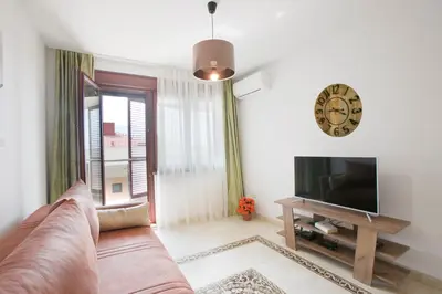 a living room with a couch and a television at Anatolia - Family Sea View one-bedroom apartment in Budva