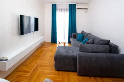a living room with two couches and a flat screen tv at Lux View in Budva