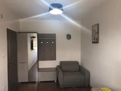 a living room with a chair and a mirror at Renta stan apartman odmor in Podgorica