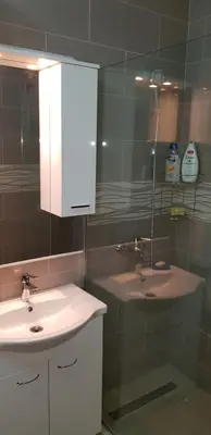 a bathroom with a sink and a glass shower at Renta stan apartman odmor in Podgorica
