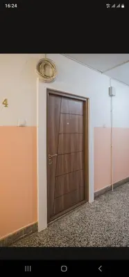 a large wooden door in an empty room at Renta stan apartman odmor in Podgorica