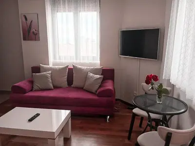 a living room with a purple couch and a table at Lux View in Petrovac na Moru