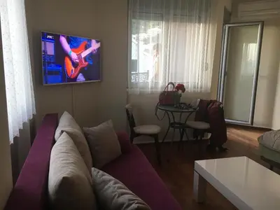 a living room with a couch and a tv on the wall at Lux View in Petrovac na Moru
