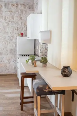 a kitchen with a table and a refrigerator at Step to Kotor bay Guesthouse in Kotor