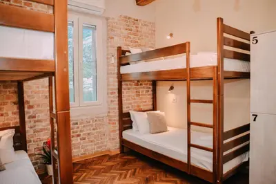 a room with two bunk beds and a brick wall at Step to Kotor bay Guesthouse in Kotor