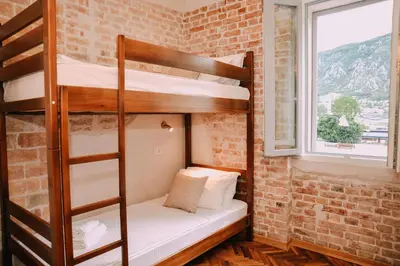 a room with bunk beds in a brick wall at Step to Kotor bay Guesthouse in Kotor