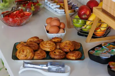 a table topped with plates of pastries and fruit at Hotel La mer in Budva