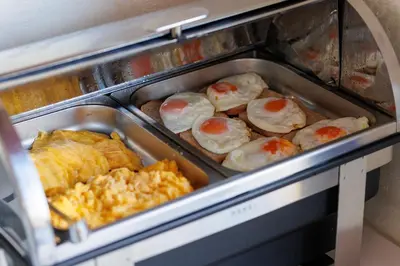 an open oven with eggs and other food in it at Hotel La mer in Budva