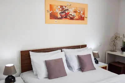 a bedroom with a bed with white and purple pillows at Hotel La mer in Budva