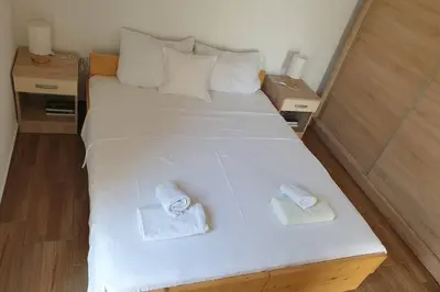 a large white bed with two towels on it at Lucia's Apartment in Sutomore