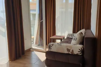a living room with a couch in front of a window at Lucia's Apartment in Sutomore