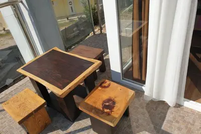 a couple of tables and benches next to a window at Lucia's Apartment in Sutomore