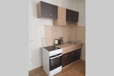a small kitchen with a stove and a sink at Lucia's Apartment in Sutomore