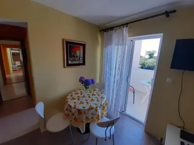 a dining room with a table and chairs and a window at Two bedroom ap in the garden in Buljarica
