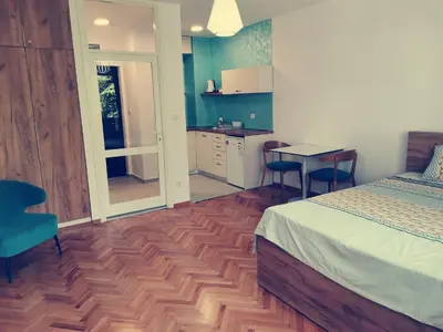 a bedroom with a bed and a table and chairs at Clock tower apartments in Podgorica