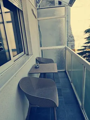 a balcony with two chairs and a table and a window at Clock tower apartments in Podgorica