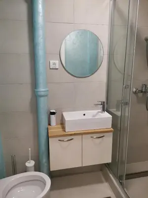 a bathroom with a toilet and a sink and a mirror at Clock tower apartments in Podgorica
