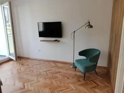 a living room with a green chair and a television at Clock tower apartments in Podgorica