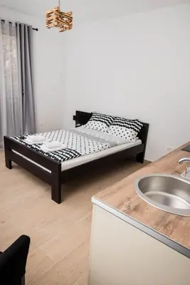 a bed in a room next to a kitchen at Studio apartment Vukcevic 2 in Podgorica