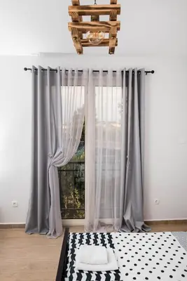 a bedroom with gray curtains and a window at Studio apartment Vukcevic 2 in Podgorica