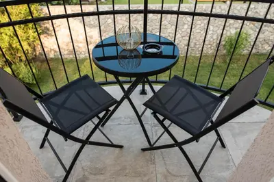 a small table and two chairs on a balcony at Studio apartment Vukcevic 2 in Podgorica