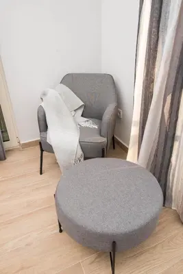 a living room with two chairs and a ottoman at Studio apartment Vukcevic 2 in Podgorica