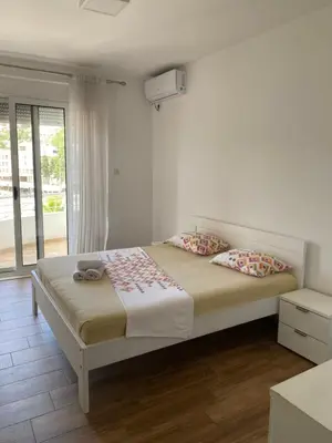 a bedroom with a bed with two pillows and a window at Seafront Apartments in Ulcinj