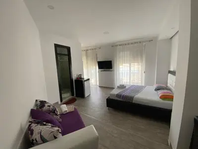 a bedroom with a bed and a couch in it at Seafront Apartments in Ulcinj