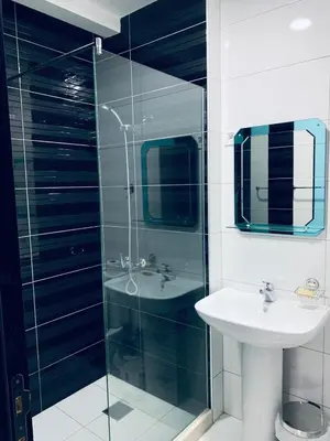 a bathroom with a glass shower and a sink at Seafront Apartments in Ulcinj