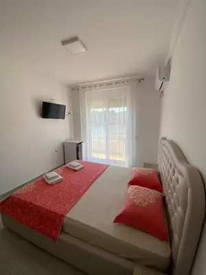 a bedroom with a large bed with red pillows at Seafront Apartments in Ulcinj