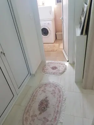 a hallway with a door open to a laundry room with rugs at Guest house Nina in Bar