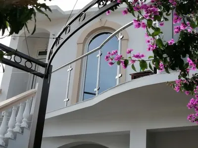 a staircase with pink flowers in front of a house at Guest house Nina in Bar