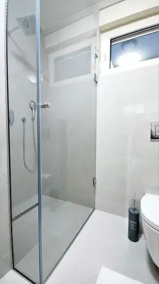 a shower in a bathroom with a glass shower stall at Kala Rooms & Suites in Budva