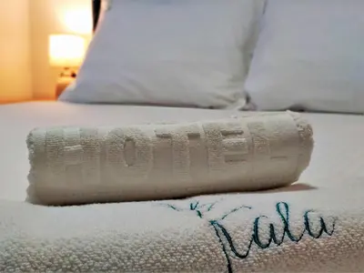 a bed with a rolled up towel on it at Kala Rooms & Suites in Budva