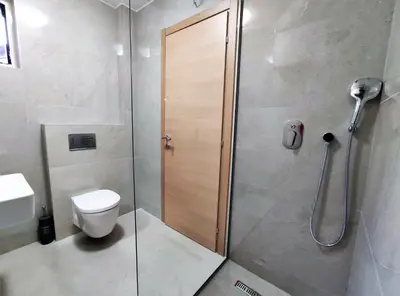 a bathroom with a shower stall and a toilet at Kala Rooms & Suites in Budva