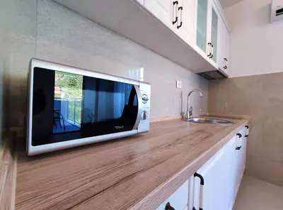 a microwave sitting on top of a counter in a kitchen at Kala Rooms & Suites in Budva