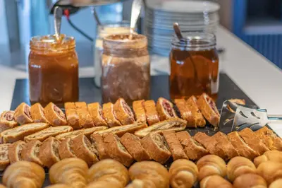 a bunch of hot dogs and donuts on a grill at Poseidon The Beach Hotel in Budva
