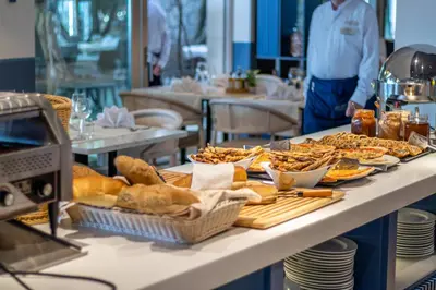 a table with a bunch of bread and pastries on it at Poseidon The Beach Hotel in Budva