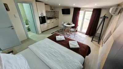 a bedroom with a large bed and a bathroom at Studio Apartments Bulevar in Podgorica