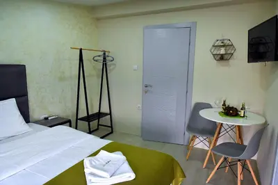a bedroom with a bed and a table and chairs at Studio Apartments Bulevar in Podgorica
