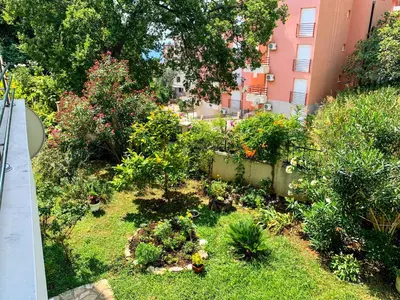 a garden with flowers and plants in front of a building at Sunny Apartment Petrovac in Petrovac na Moru