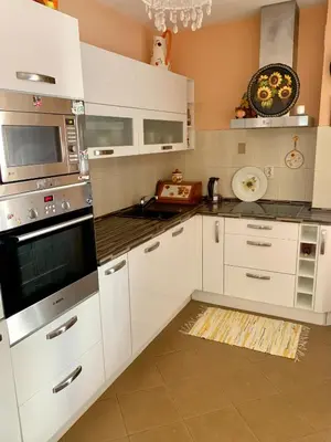 a kitchen with white cabinets and stainless steel appliances at Sunny Apartment Petrovac in Petrovac na Moru