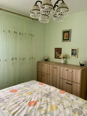 a bedroom with a bed and two chandeliers at Sunny Apartment Petrovac in Petrovac na Moru