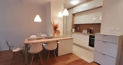 a kitchen with white cabinets and a table and chairs at Lux Apartment PortoVista in Bar